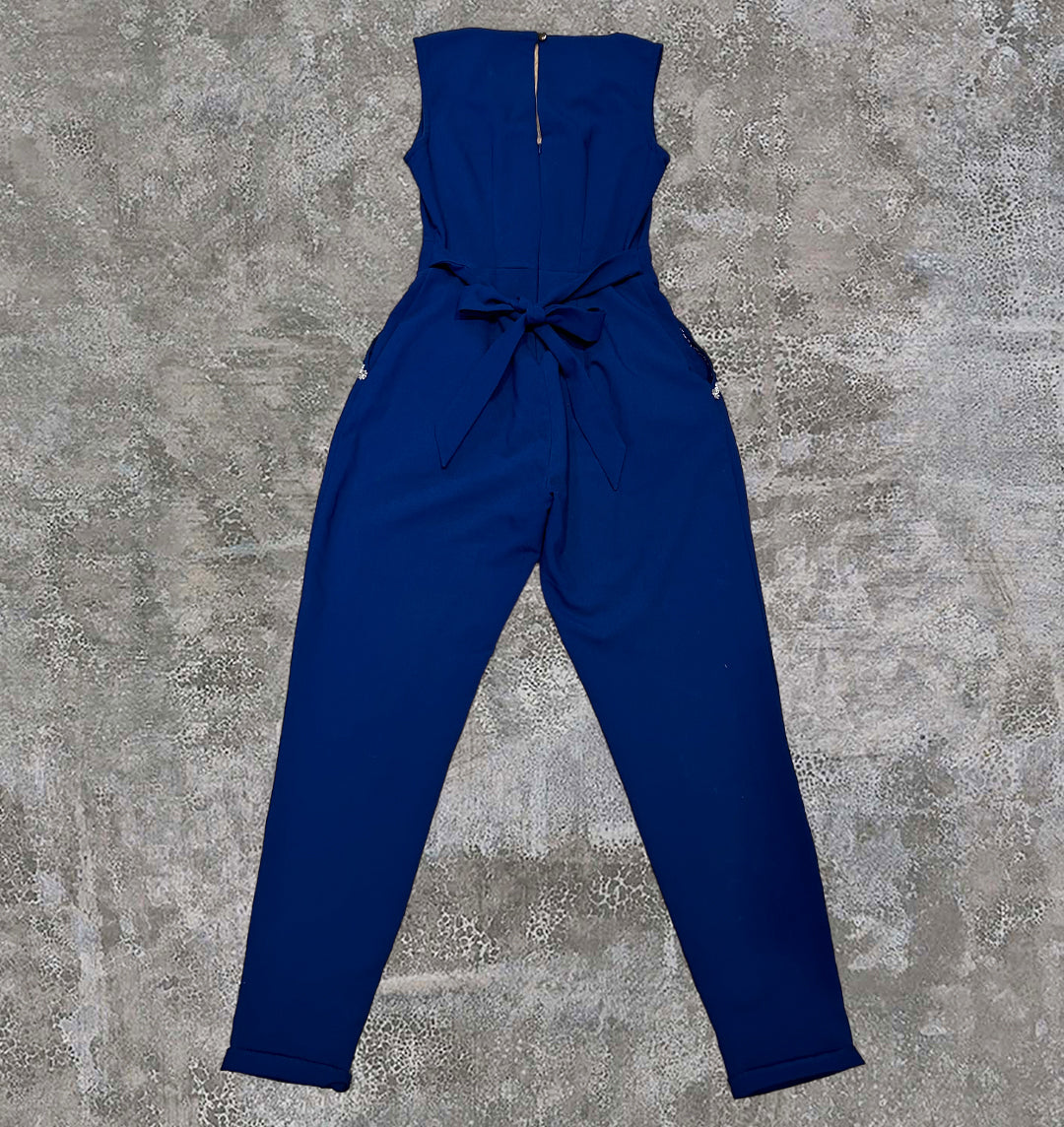 Plain back of the BRICK + BONE blue jumpsuit. Bow detail wrapping around the waist