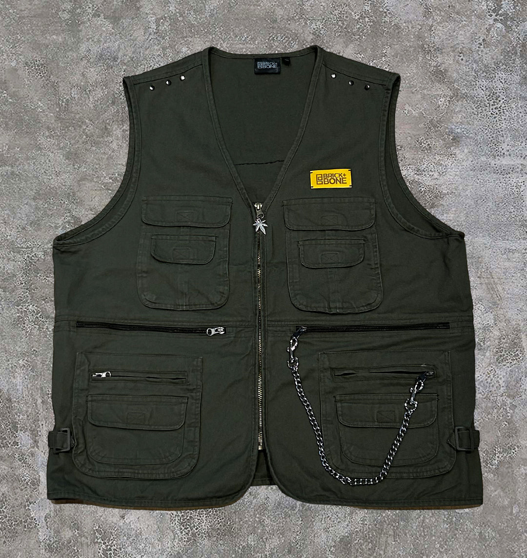 Khaki utility vest with chain details and studs.