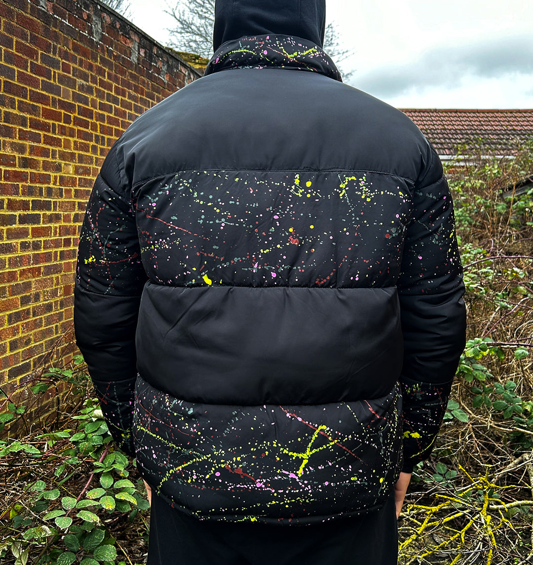 Upcycled puffer jacket with blocked out paint splatter on the back